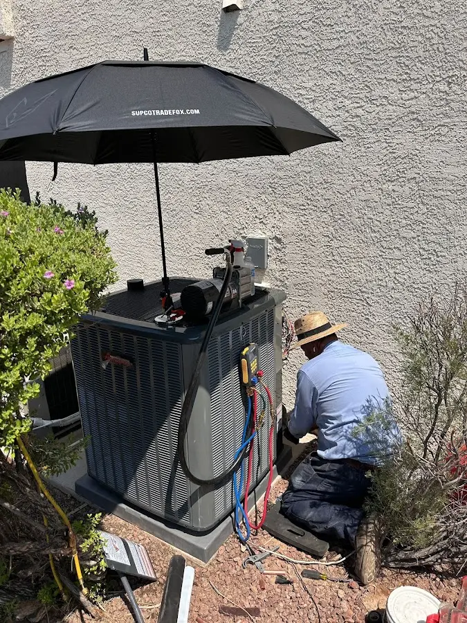 HVAC technician performing outdoor AC maintenance in Little Silver