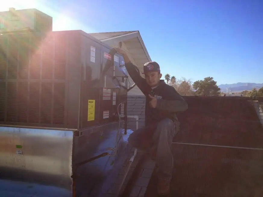 HVAC technician performing AC Tune-Up on a rooftop unit in Little Silver
